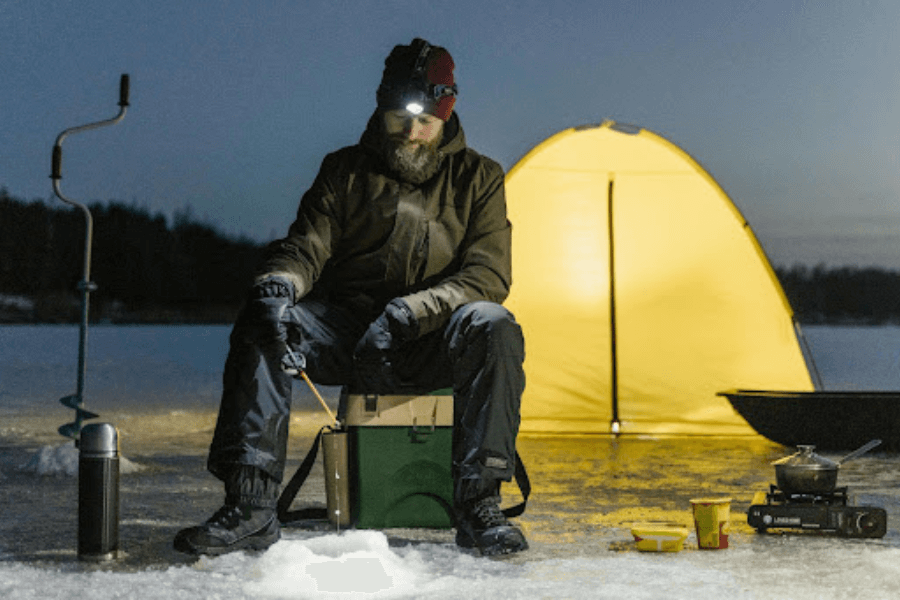 Man in front of tent, camping in winter.
